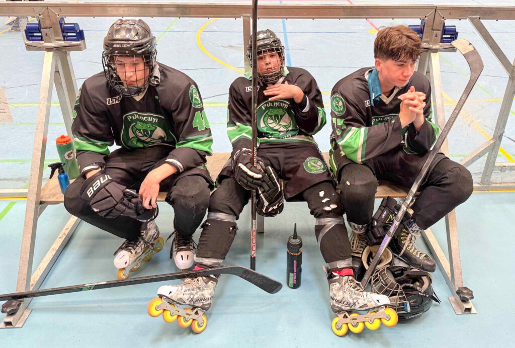 Drei erschöpfte Pulheim-Vipers-Spieler sitzen auf der Bank während einer Pause im Inlinehockeyspiel