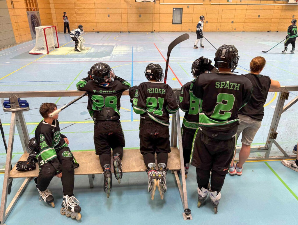 Pulheimer Vipers Jugend auf der Auswechselbank bei einem Inlinehockeyspiel in der Halle, Blick aufs Spielfeld und Tor